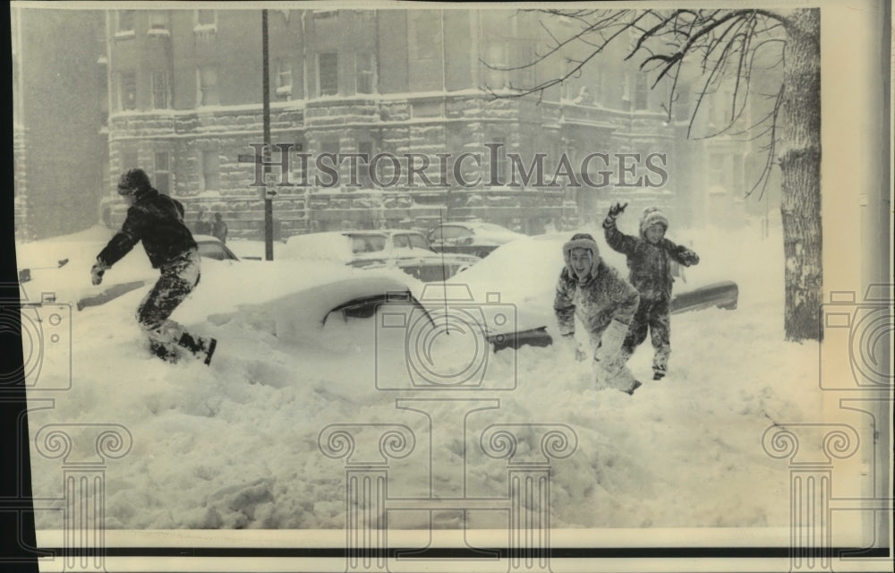 1967 Press Photo Gleeful Youths Toss Snowballs at Car Rooftop Level in Chicago - Historic Images