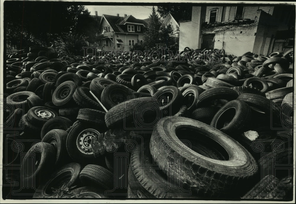 1988, Thousands or old tires piled in a yard behind a vacant house - Historic Images