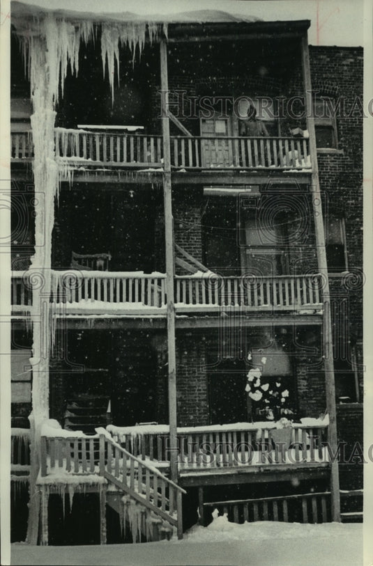 1979, Woman tosses trash over snowy railing in Chicago - mjc12547 - Historic Images