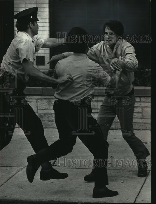 1974 Press Photo Milwaukee police officers subdued a man entering the plant - Historic Images