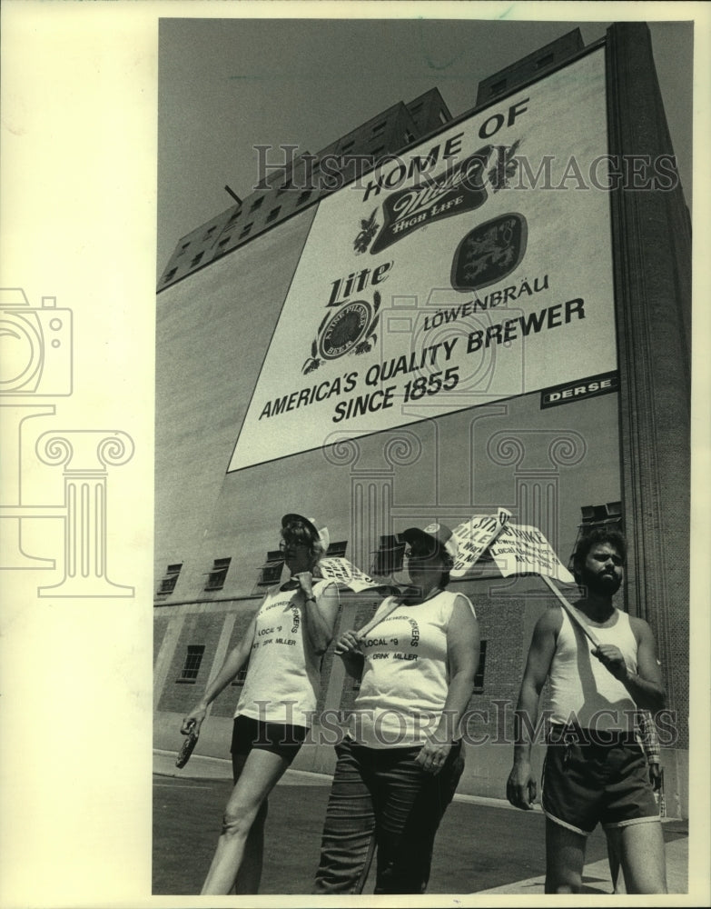 1983, Strikers with placards in front of brewery ad in Milwaukee - Historic Images