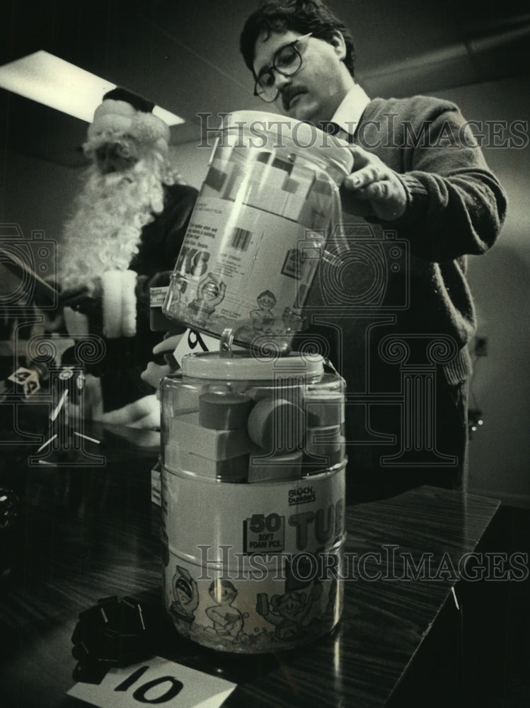 1989 Press Photo Tom Conrad with Santa holding toy blocks for press, Wisconsin. - Historic Images