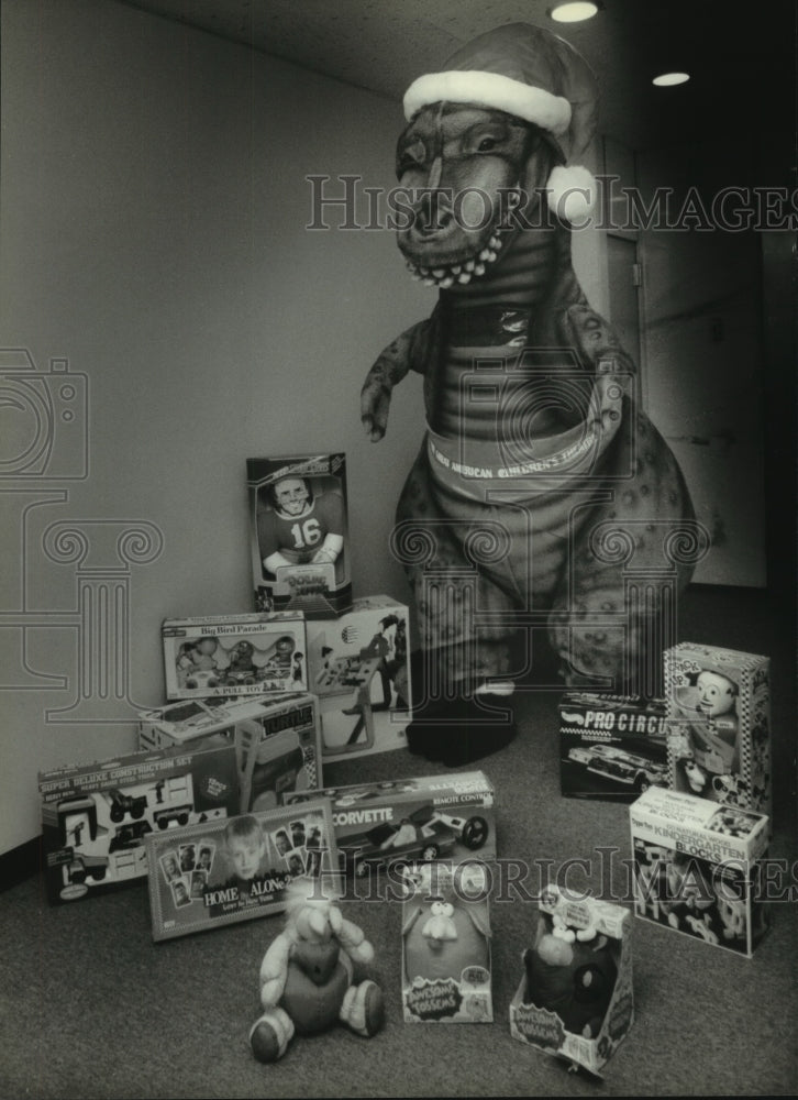 1993 Chad Bunker playing Santasaurus shows off some Christmas toys - Historic Images