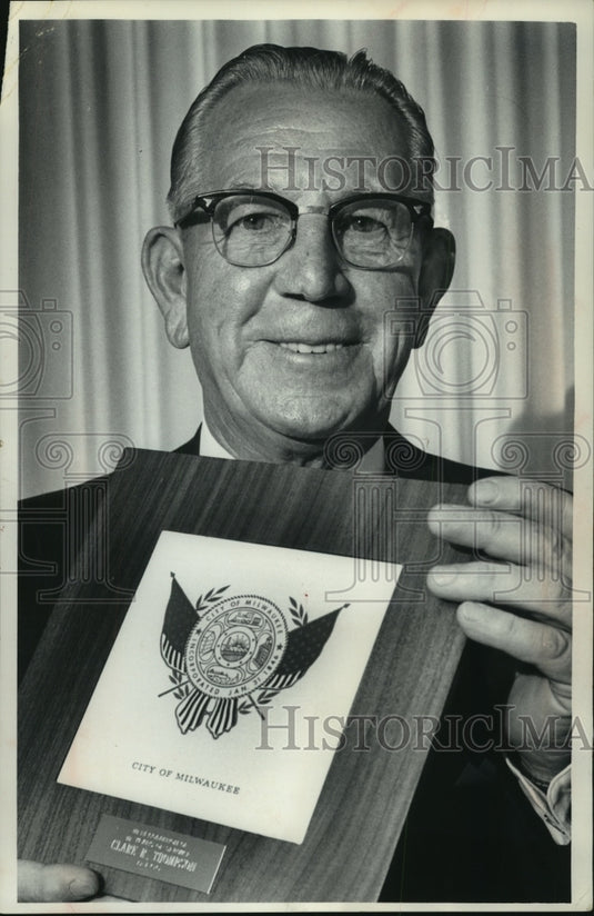1965, Clare R. Thompson hold plaque from city board, Milwaukee - Historic Images
