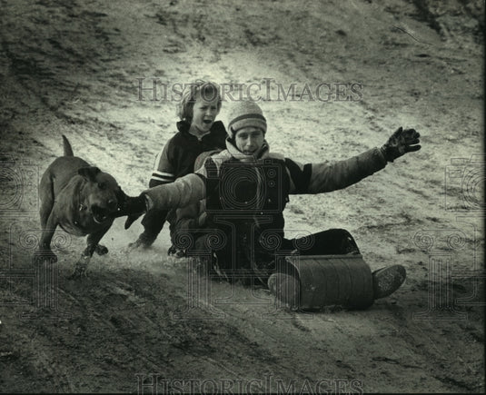 1990 Press Photo Gene & Hailey Kopacz toboggan with dog Moose, Lake Park - Historic Images