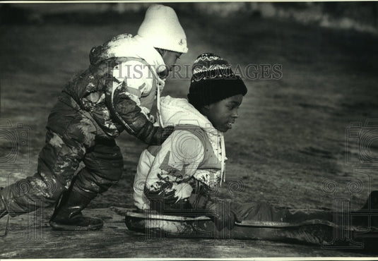 1993 Latoya Swiams pushes sister down muddy hill near St Mary's - Historic Images