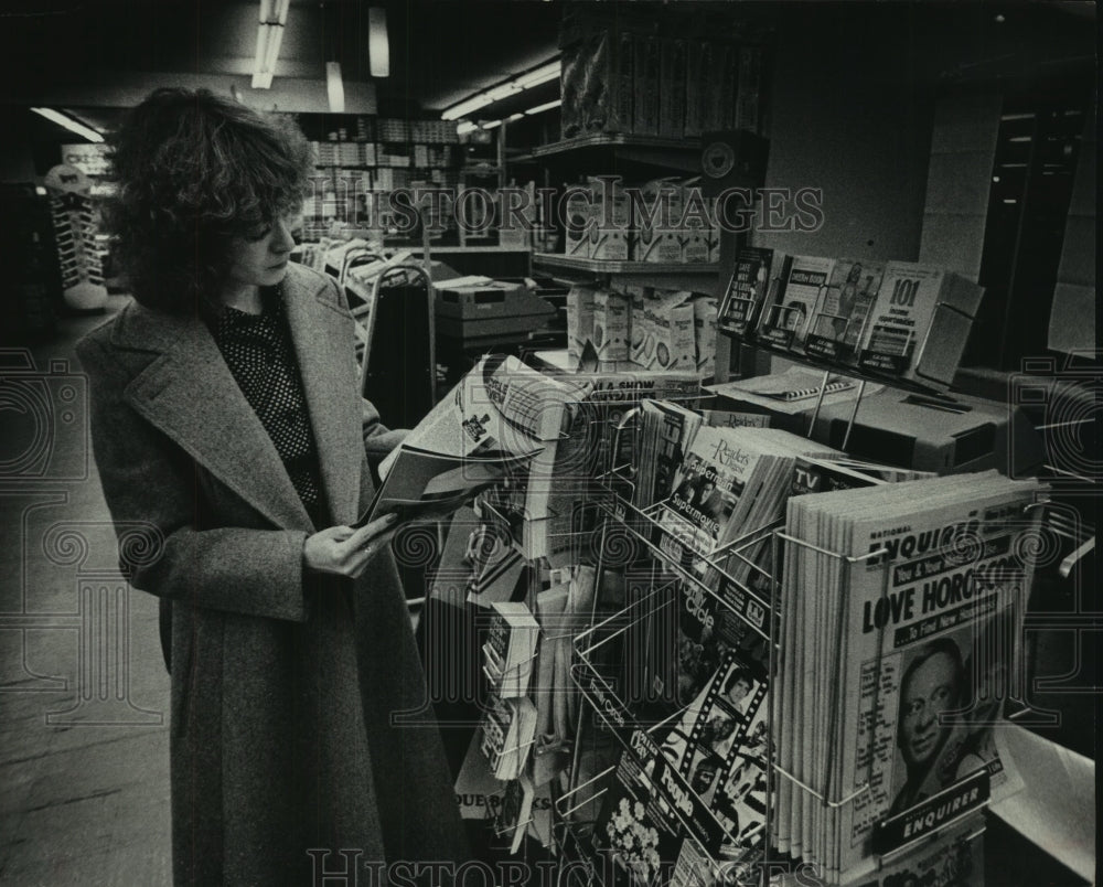 1979, A reader checked out a periodical at the grocery store - Historic Images