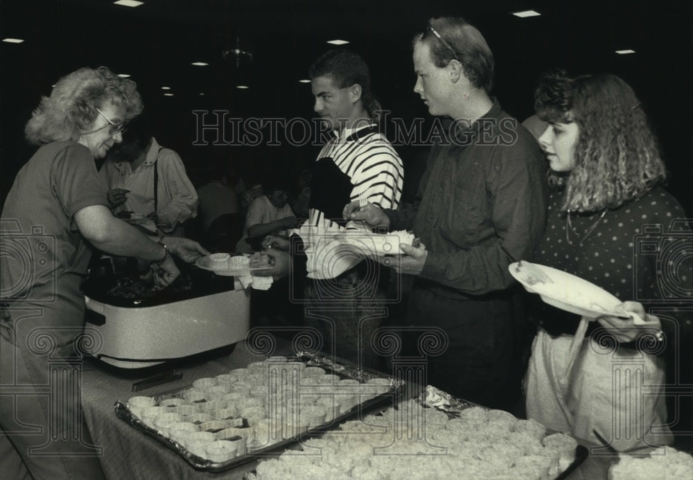 1991, Sandie Schone serves up smelt to benefit area youths in Sussex - Historic Images