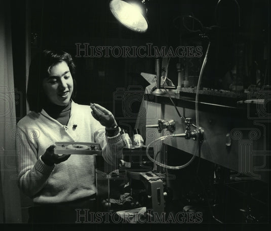 1984 Milwaukee student Maryellen Maneri looks at snail that can glow - Historic Images