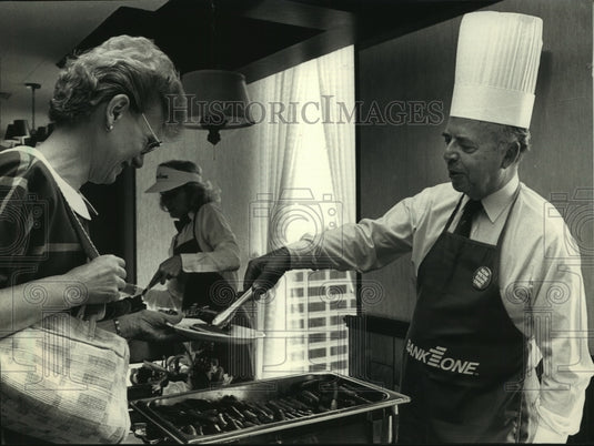 1988, George Slater chairman of Bank One Wisconsin serving breakfast - Historic Images