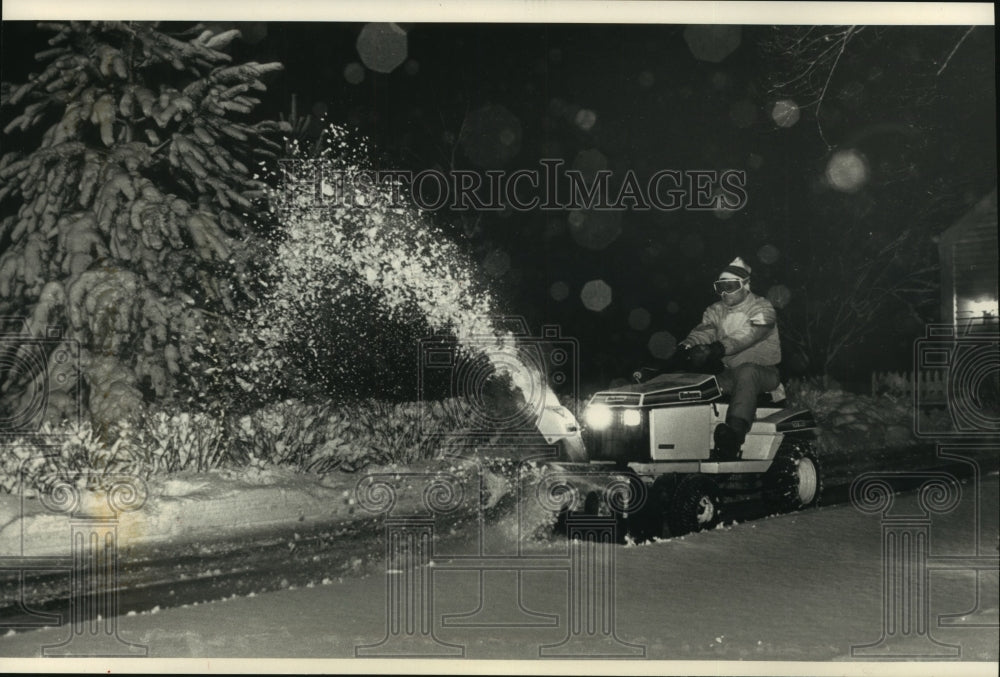 1993, Roger Smith, Mequon, on his lawn tractor plowing his driveway. - Historic Images