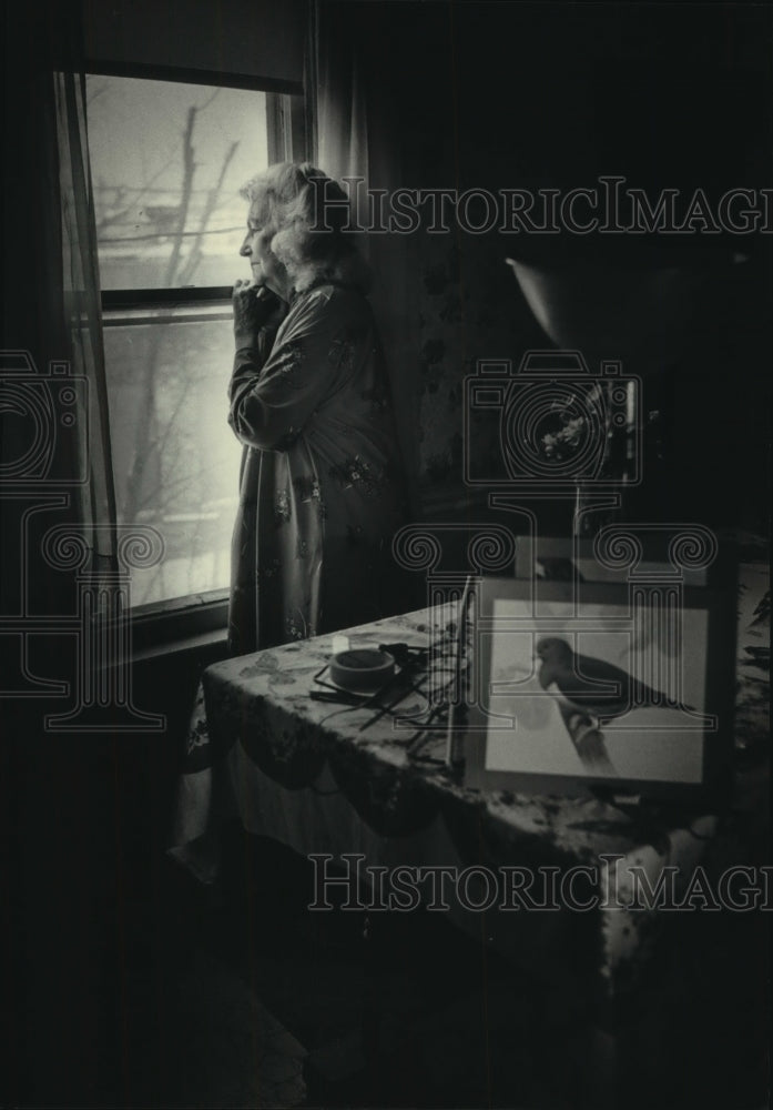 1986 Press Photo Artist Florence Sutter looks out the window of her home - Historic Images