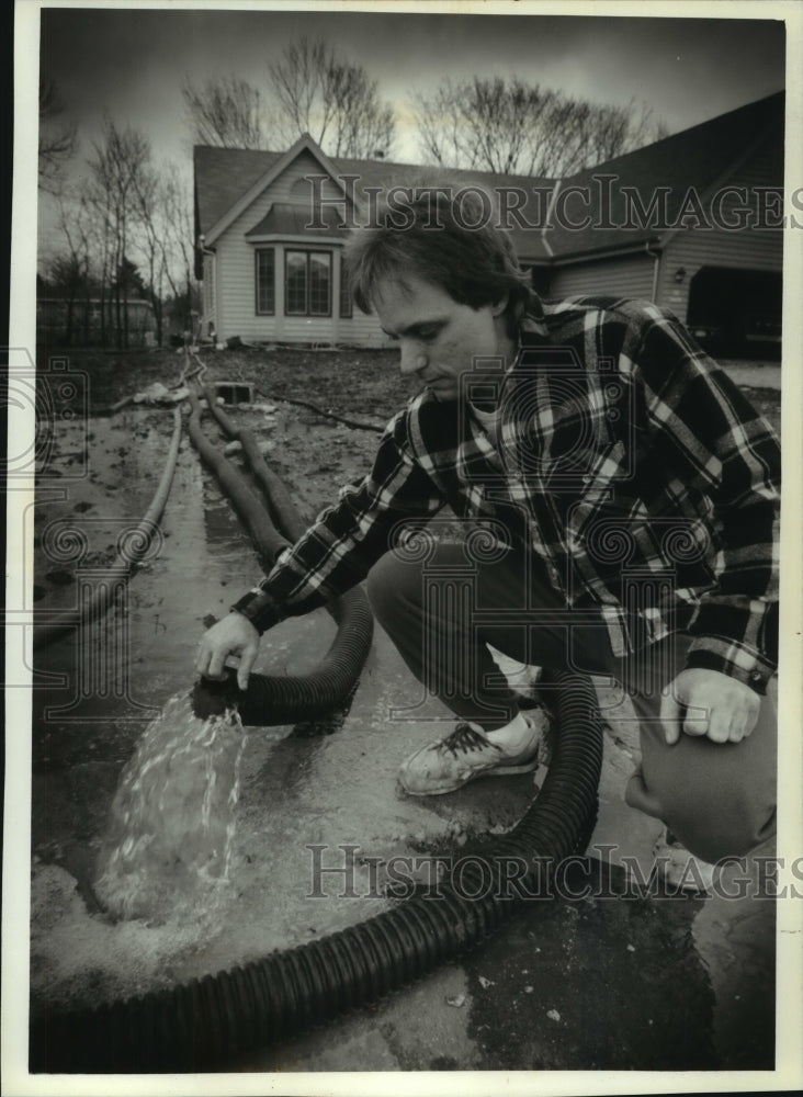 1993, Tim Schwalbach pumps out flooded basement, Sussex, WI - Historic Images