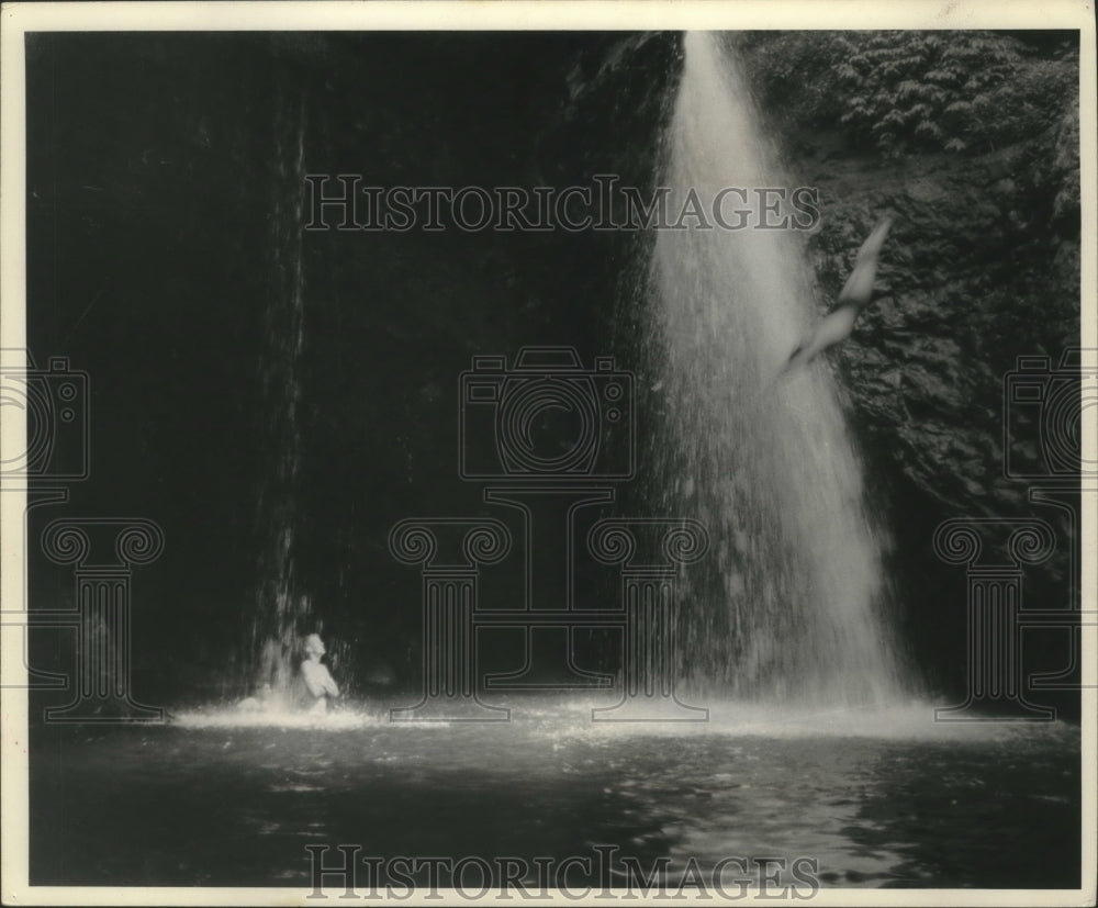 1964 Press Photo Man diving off cliff into a waterfall pool - mjc14448 - Historic Images