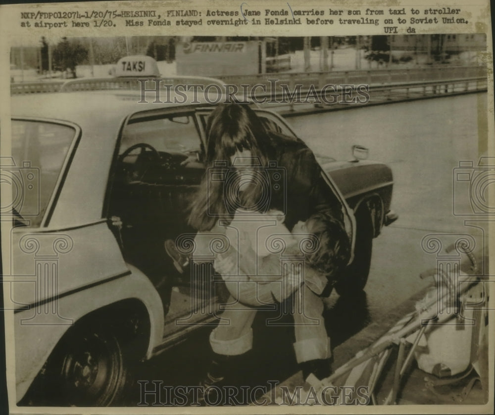 1975 Press Photo Actress Jane Fonda carries her son in Helsinki, Finland - Historic Images