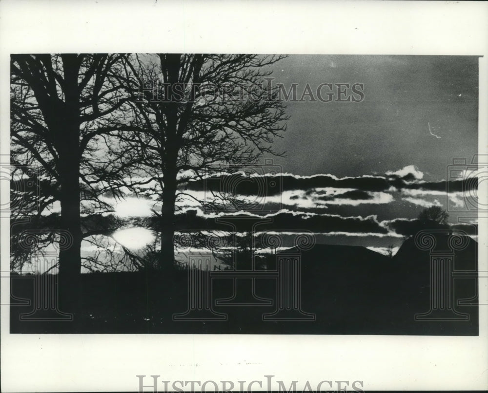 1974, Setting sun above farm with lined clouds, Manitowoc County. - Historic Images