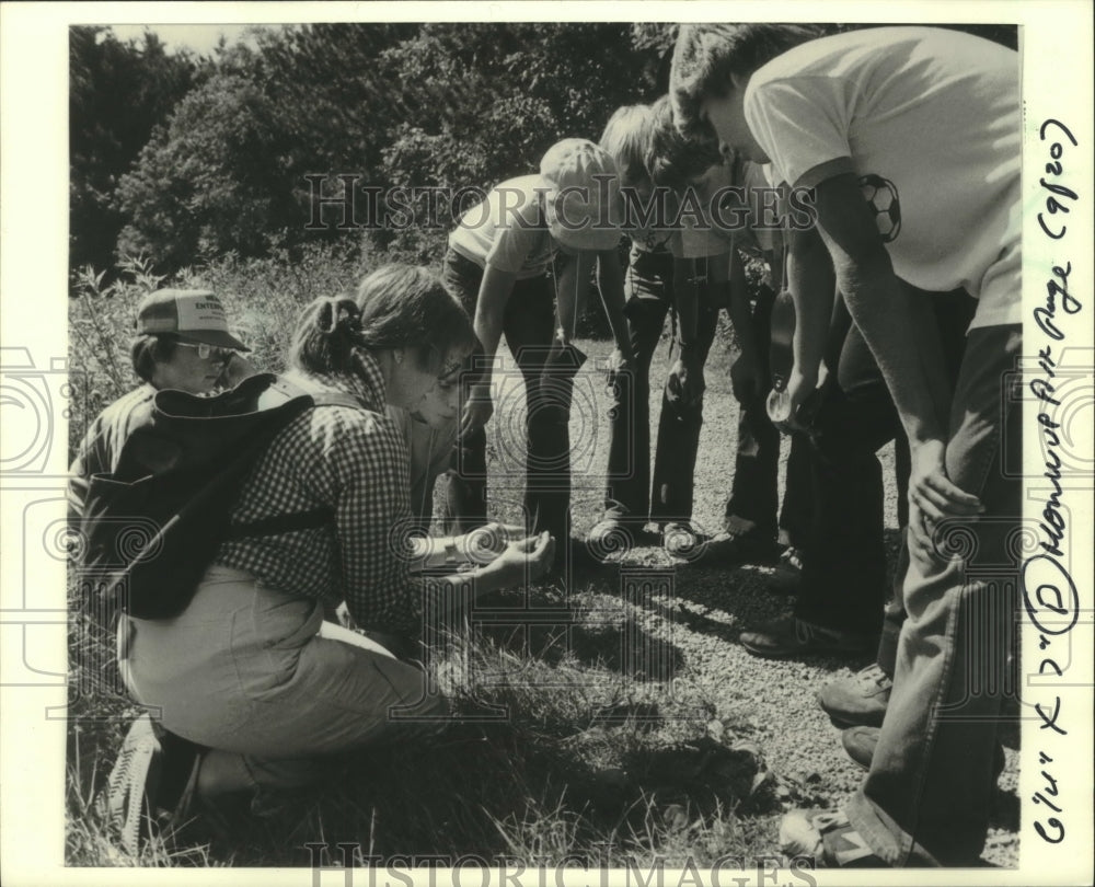 1982 Naturalist, students looking at soil on field trip, Wisconsin. - Historic Images