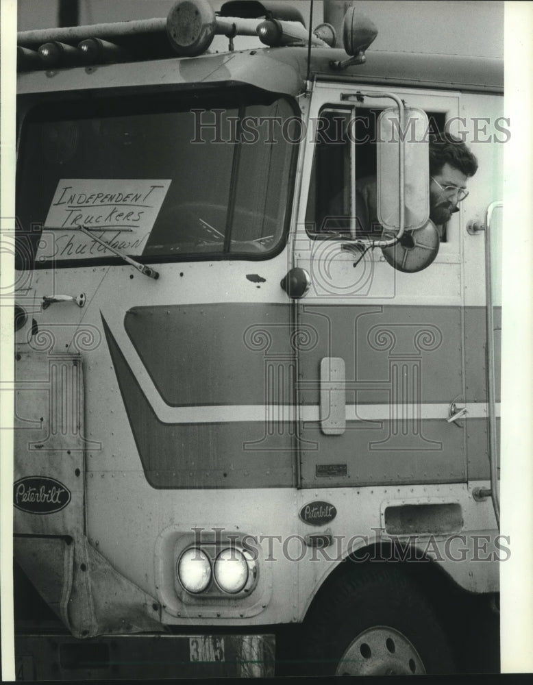 1983, An independent trucker looks out from his rig at gathering - Historic Images