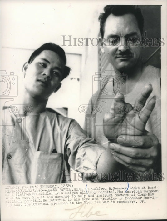 1964, Dr. Alfred Swanson examines a Vietnamese soldier in Saigon - Historic Images