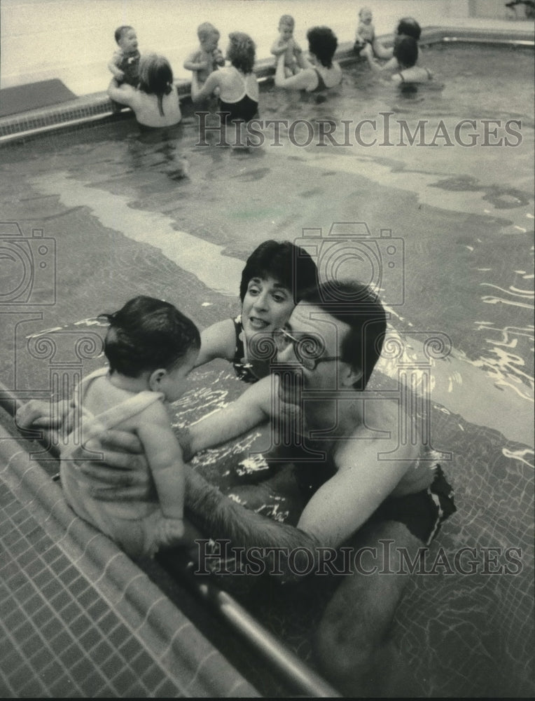 1984, Richard and Jo Ellen Hartman swim with daughter, Rachel - Historic Images