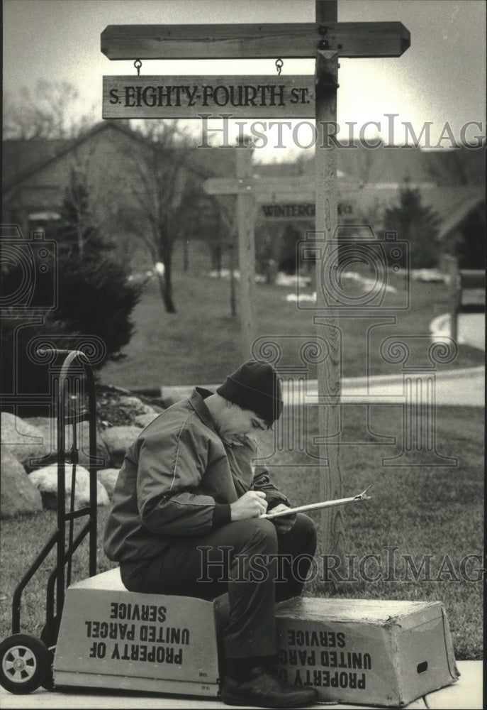 1992 Randy Kaye, checks his records of deliveries for United Parcel. - Historic Images