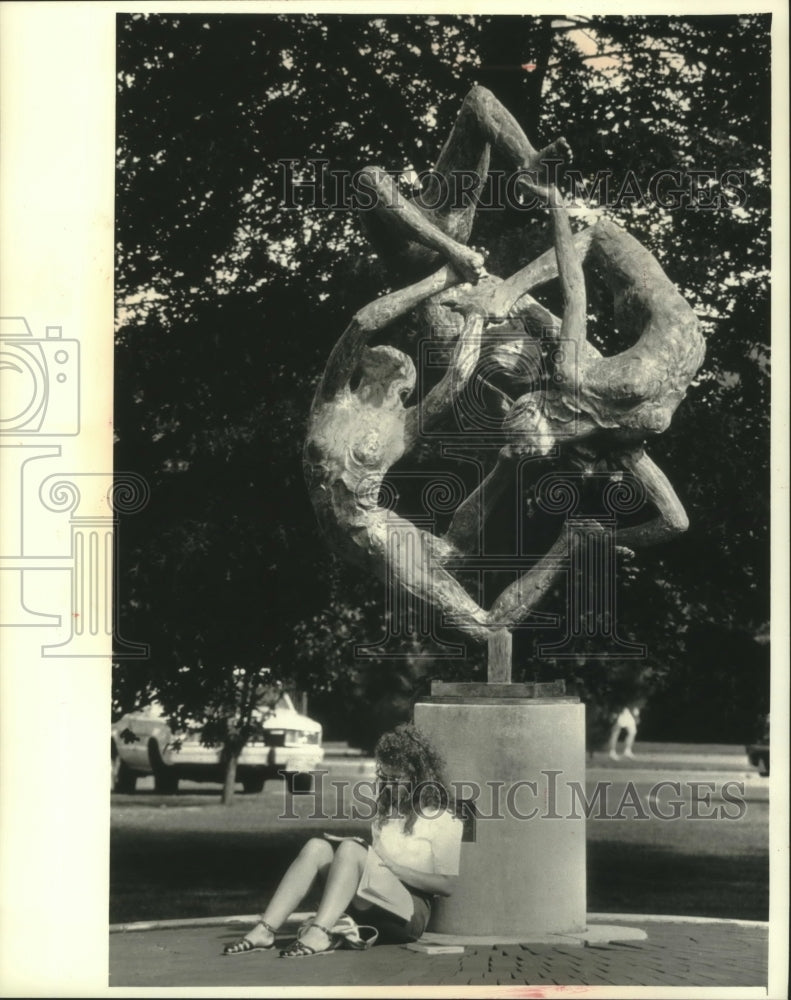 1991 Student sits by statue titled &quot;Sprites&quot; at UW Eau Claire - Historic Images