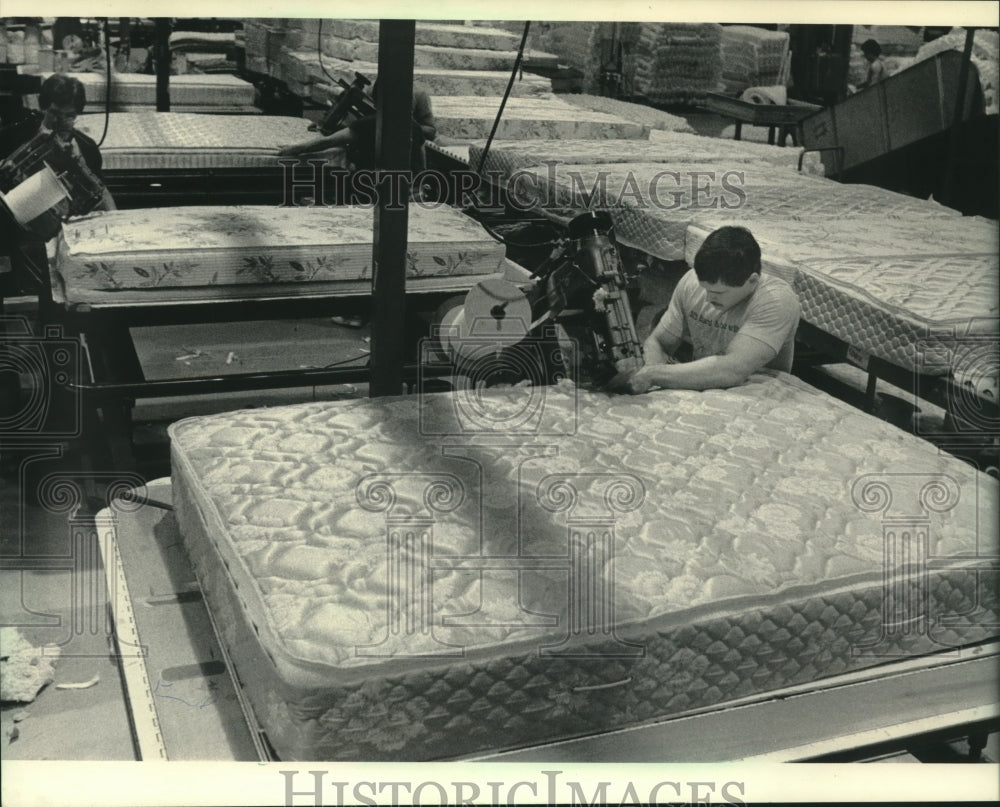 1984 Gerald Schroeder uses sewing machine on mattress, Janesville. - Historic Images