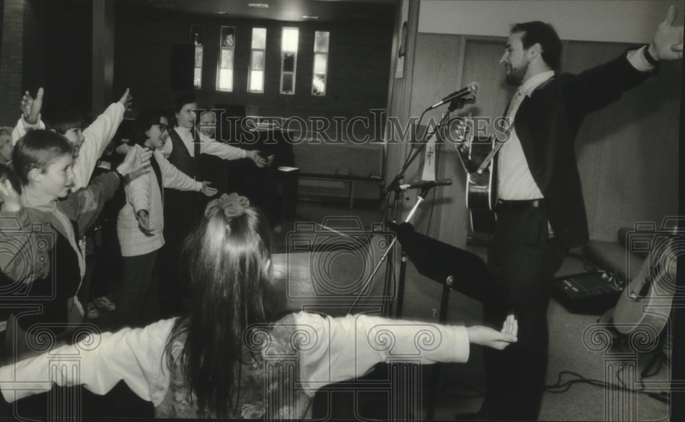 1994 Press Photo Reverend Bryan Sirchio sings with children in Brookfield - Historic Images