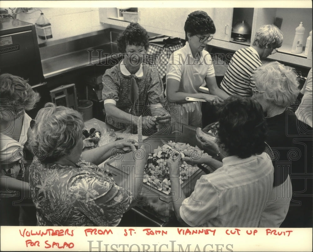 1984, Volunteers from St. John Vianney Catholic Church prepare food - Historic Images