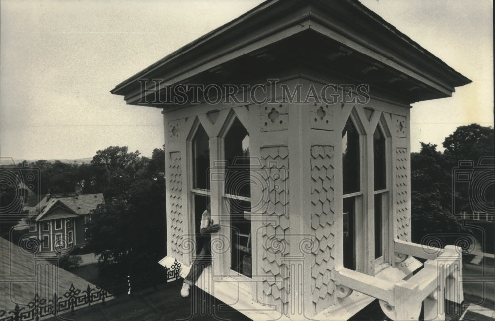 1992 Press Photo Ernst Schlieter climbs out the window of Victorian Gothic Home - Historic Images