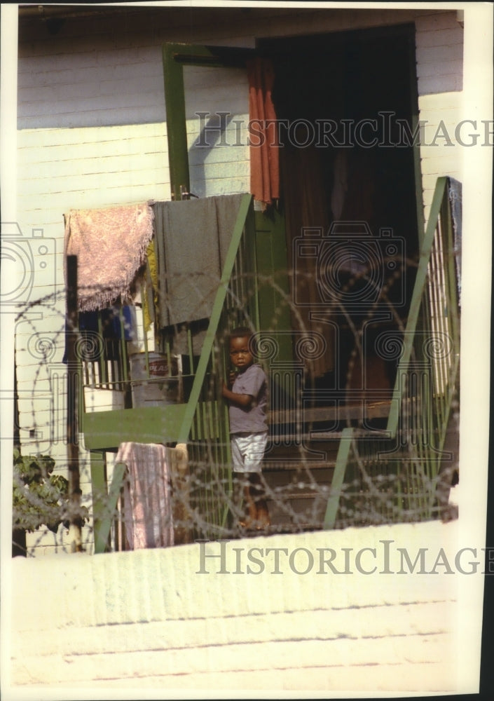 1993 Boy in his backyard surrounded by barbed wire in Johannesburg - Historic Images