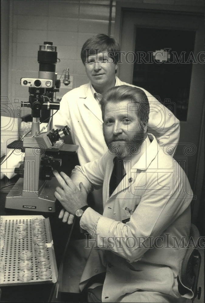 1987 Press Photo James Sedmak and Gerald Sedmak, next to microscope, Wisconsin. - Historic Images