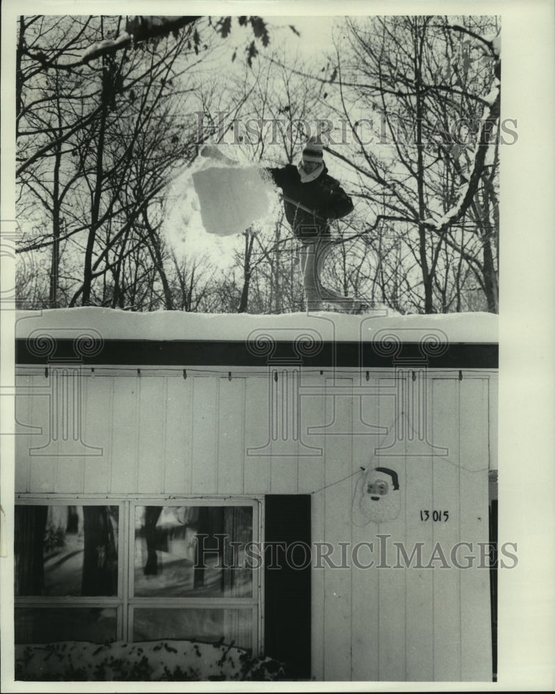 1979, Donald Freier cleans snow off the roof of home New Berlin, WI - Historic Images