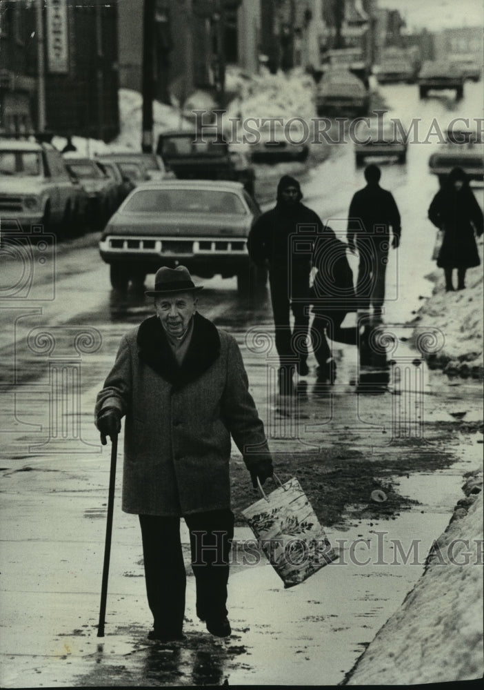 1979 William Berg trudges along flooded road in Milwaukee - Historic Images