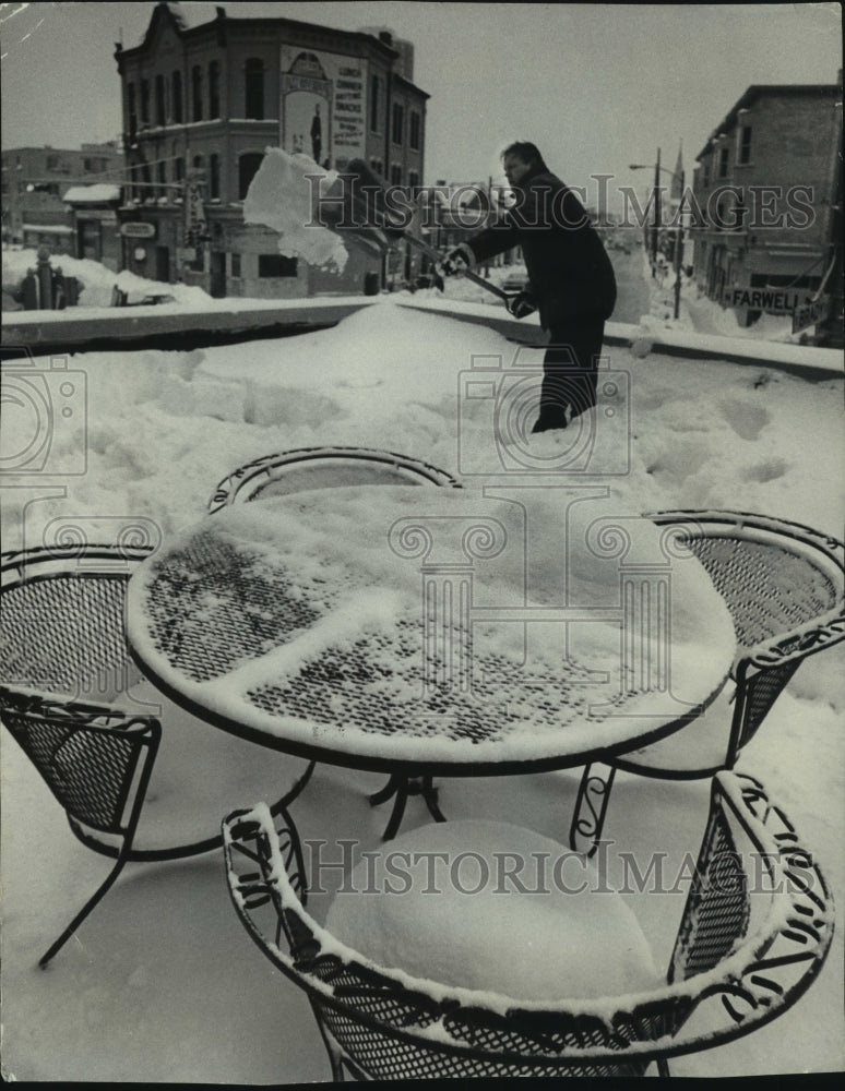 1979, Don Peterson clears off patio furniture at Farwell and Brady - Historic Images