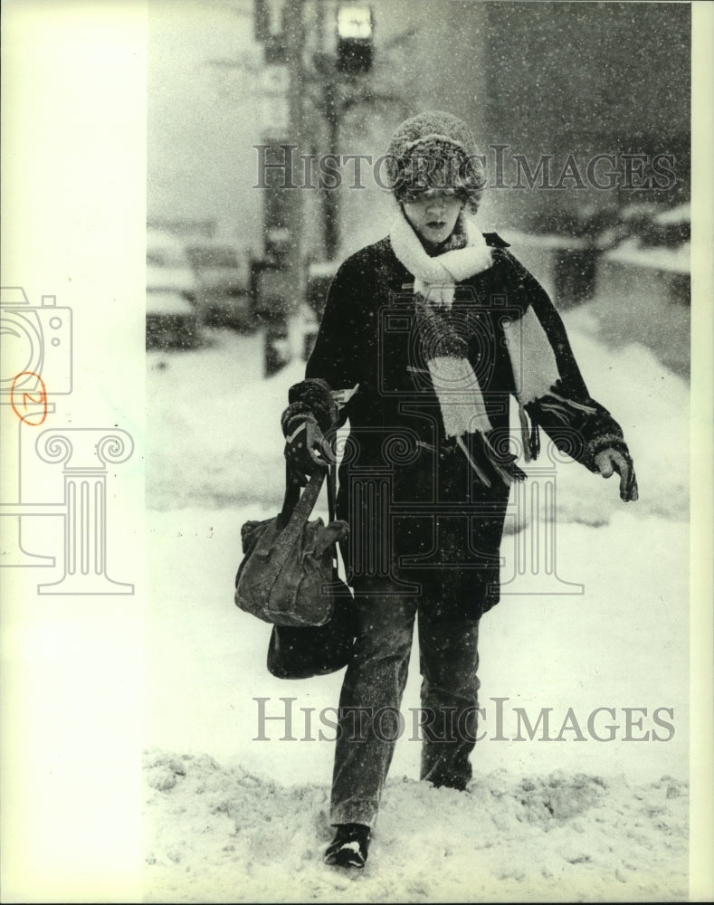 1982 Press Photo Woman crosses E. Kilbourn Ave. at N. Broadway in a snowstorm - Historic Images