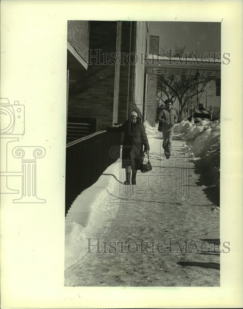 1982, A woman walks on snow-covered Kilbourn Ave in MIlwaukee - Historic Images