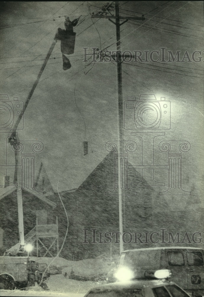 1982, Workman struggles to repair broken power line Milwaukee WI - Historic Images