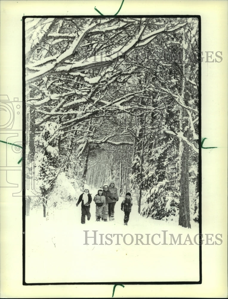 1983, Children walk in snow in Oconomowoc during a snow day - Historic Images