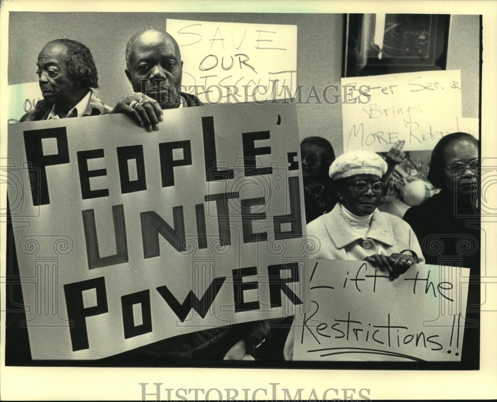 1987 David Young, holding sign at left, at bus fare budget hearing - Historic Images