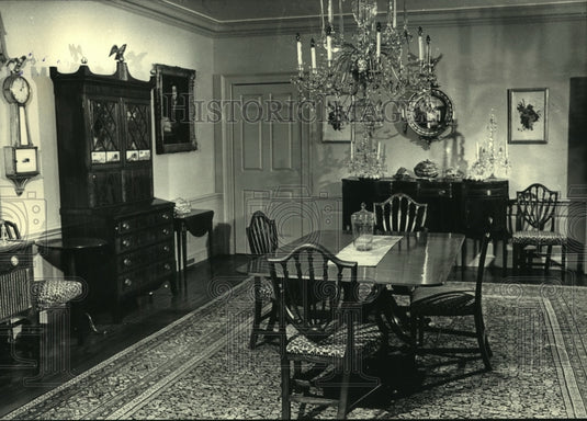 1988 A Sheraton-type dining room filled with antique furniture. - Historic Images