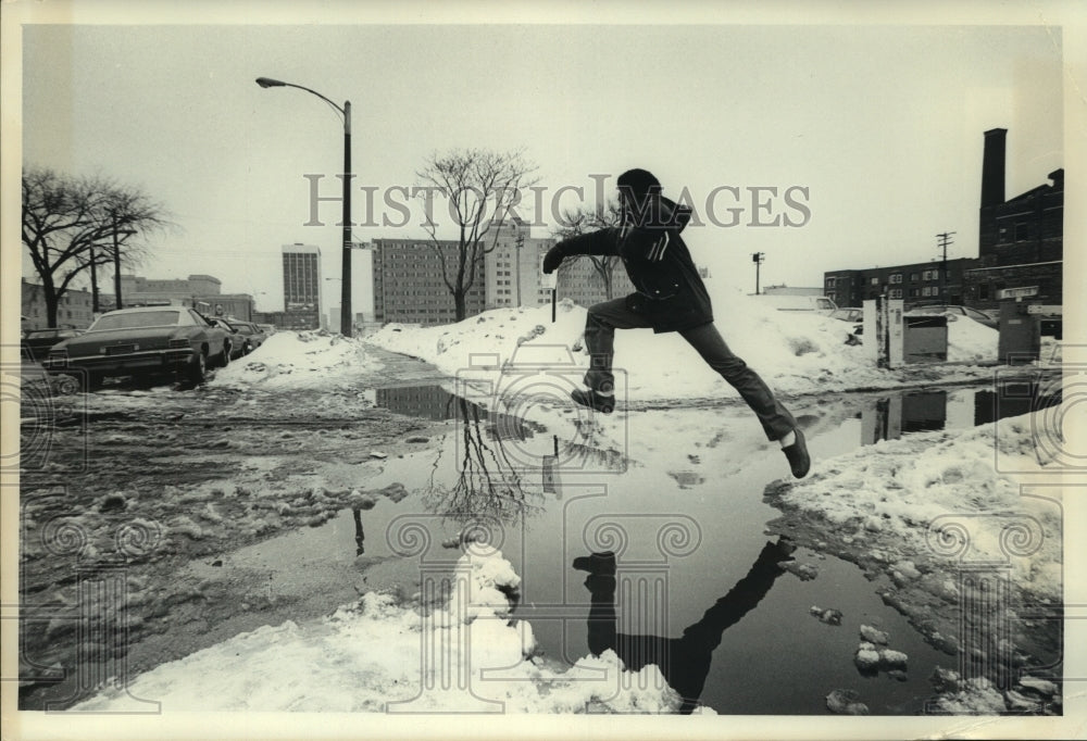 1979, Greg Armstrong jumps over puddle Wisconsin - mjc18088 - Historic Images