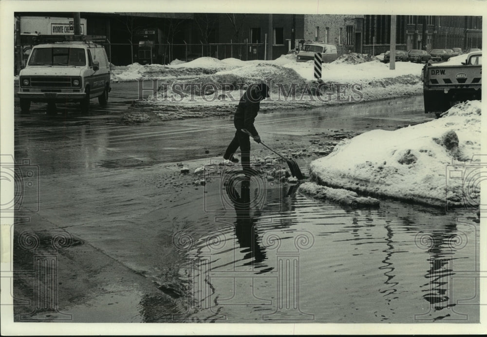 1979, Dept of Public Works employee clears debris, Milwaukee - Historic Images