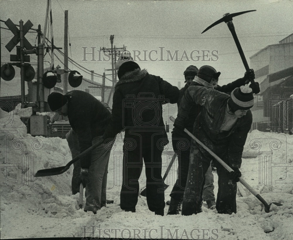 1979 Press Photo Harnischfeger Corp workers dig out railroad switch in Cudahy - Historic Images