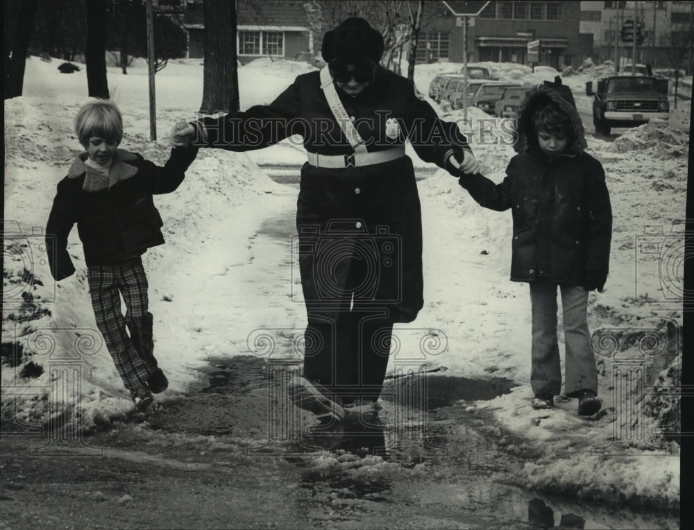 1979, Karen Klafke helps two students cross wet streets, Milwaukee - Historic Images