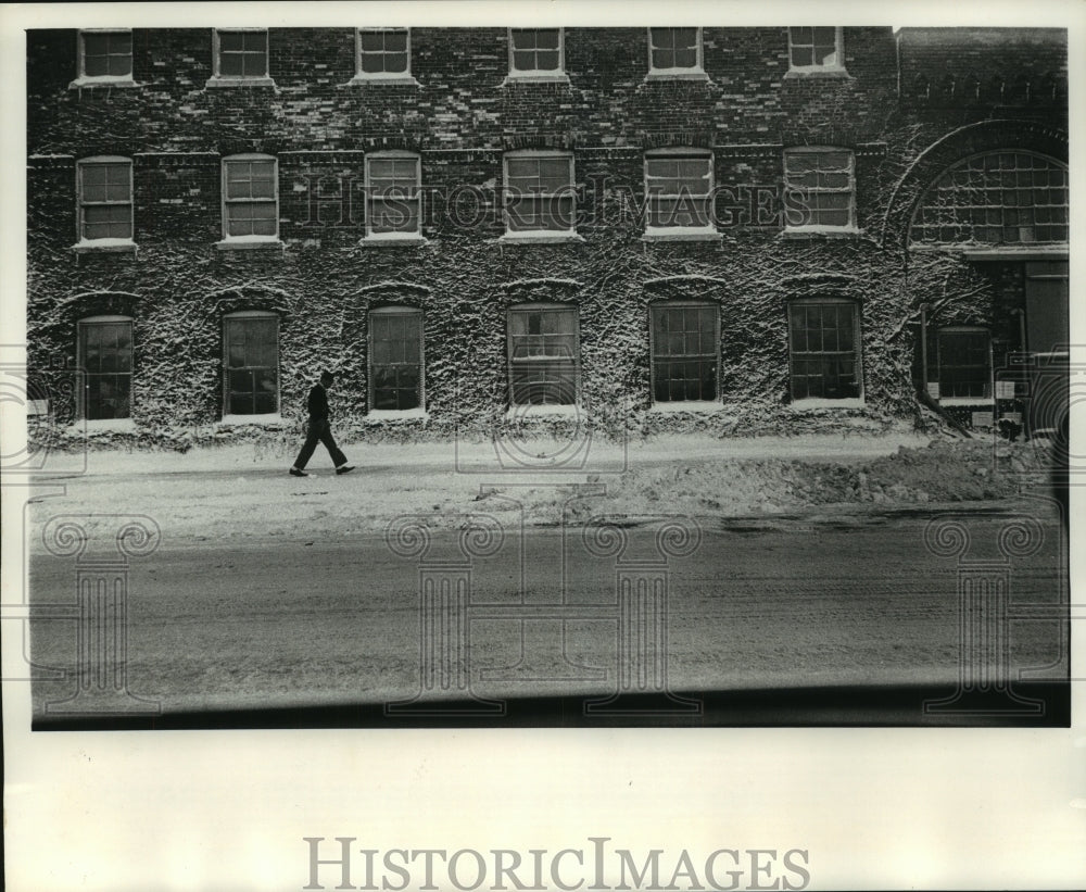 1964 Press Photo Man walks by snow covered Pfister & Vogel Tanning Co. building - Historic Images