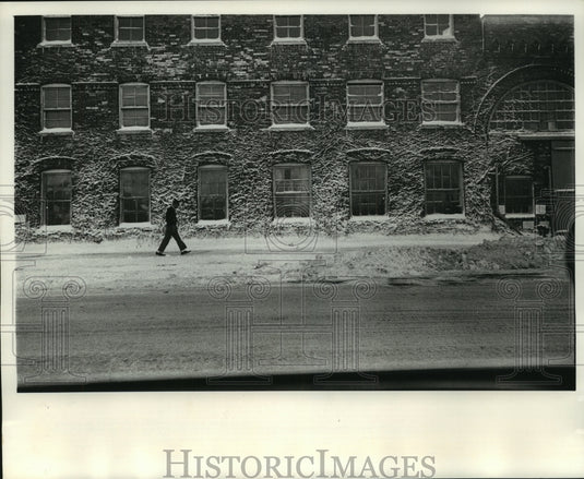 1964 Press Photo Man walks by snow covered Pfister & Vogel Tanning Co. building - Historic Images