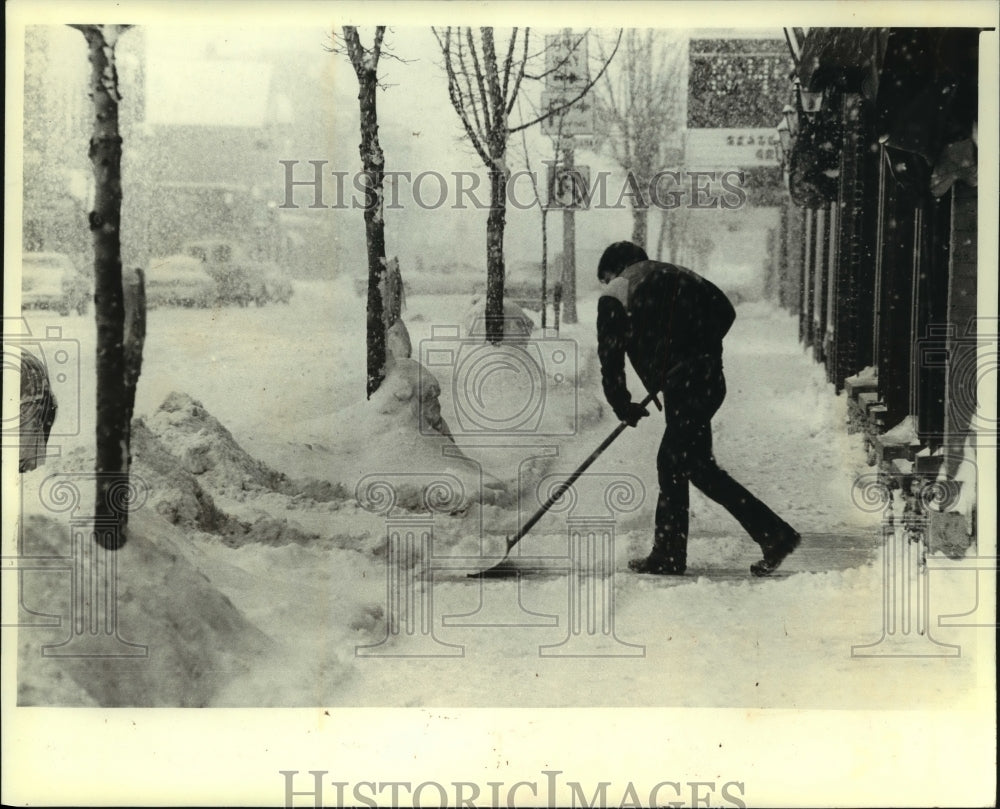 1982 Man clearing snow from a sidewalk in Sturgeon Bay - Historic Images