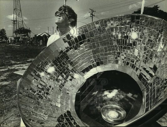 1979, Robert Mueller cooks a hamburger in a solar oven at the fair - Historic Images