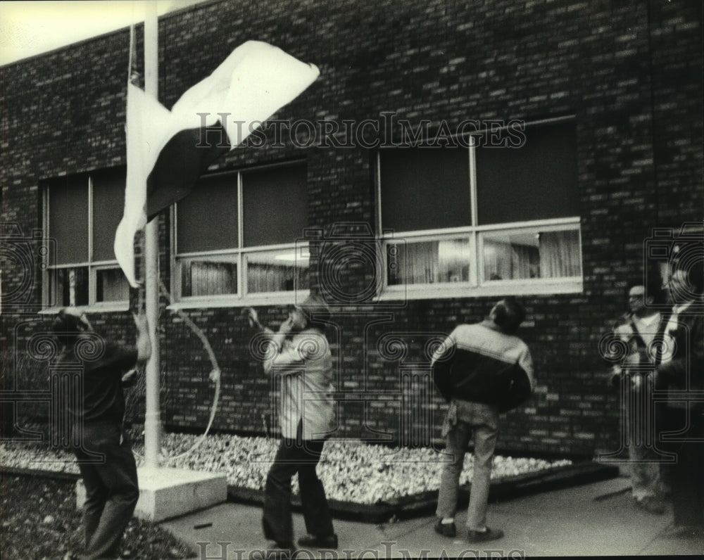 1981, Workers at Teledyne Wisconsin Motor plant lower a Japanese flag - Historic Images